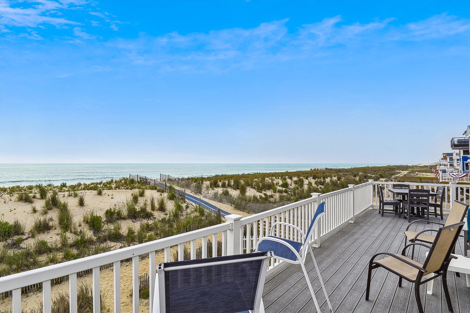 Spacious beachfront deck with stunning ocean views, comfortable seating, and direct access to pristine sandy shores—your perfect coastal retreat awaits.