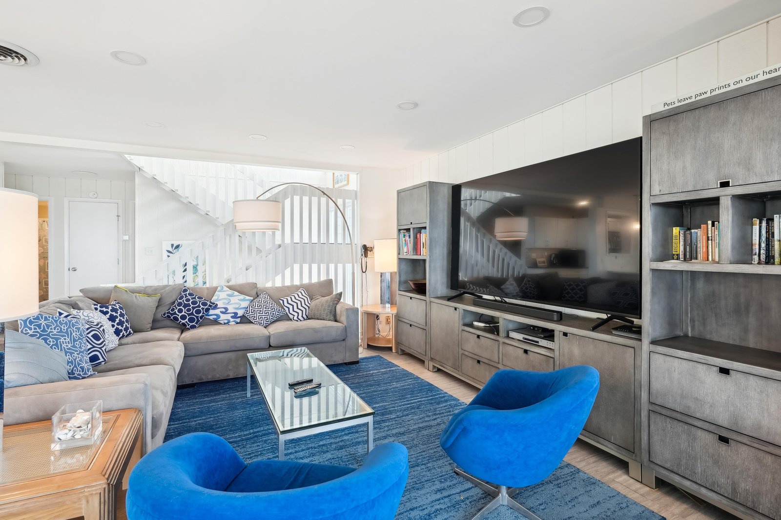 Sink into the plush sectional, prop your feet on the coffee table, and let the vibrant blue swivel chairs and coastal-inspired accents wrap you in comfort. Your home away from home awaits.