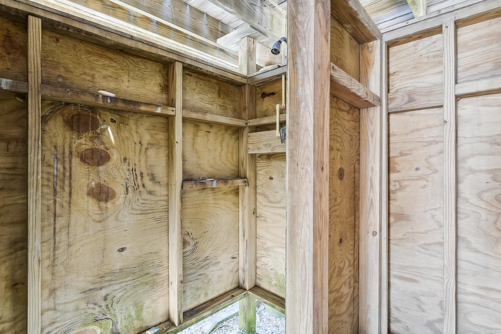 An outdoor shower with wooden walls provides a refreshing rinse after sandy beach days or poolside fun, blending rustic charm with practical convenience.