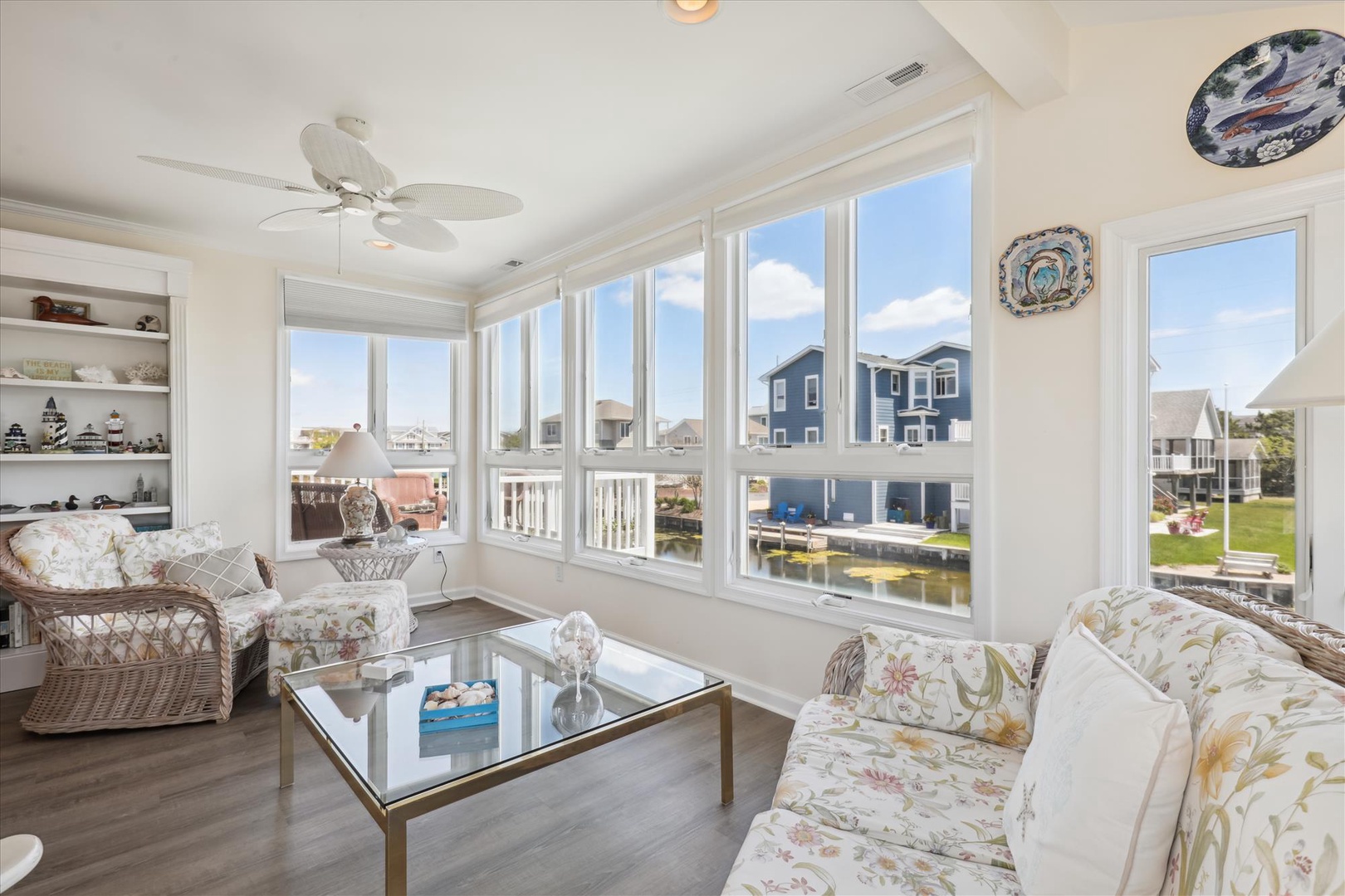 Sink into plush seating and take in peaceful waterfront views through expansive windows. The bright, airy sunroom invites you to relax with a book or enjoy morning coffee surrounded by coastal charm.