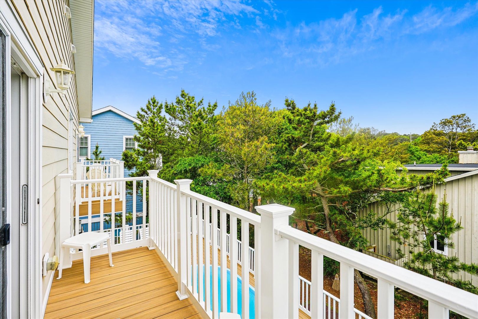 Peaceful neighborhood nestled among lush greenery under clear blue skies, offering a serene coastal setting near the property.