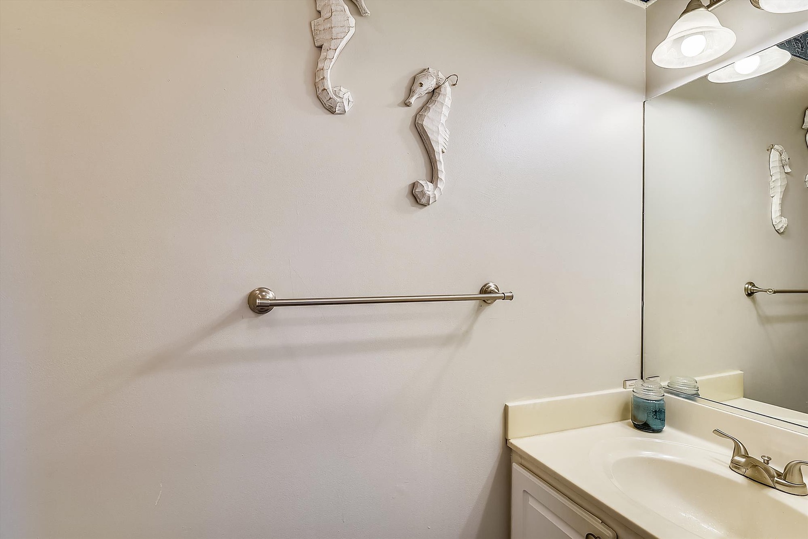 Your private bathroom features coastal decor and thoughtful touches, with a clean vanity and charming seahorse accents that bring a beachy, relaxed feel to your stay.