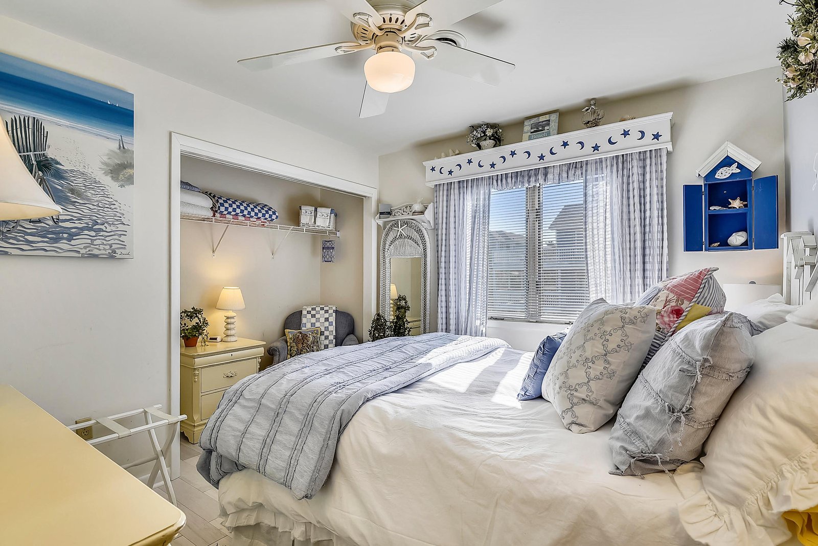 Drift off in this cozy coastal bedroom with soft linens, a ceiling fan for comfort, and beach-themed décor that welcomes you to pure relaxation.