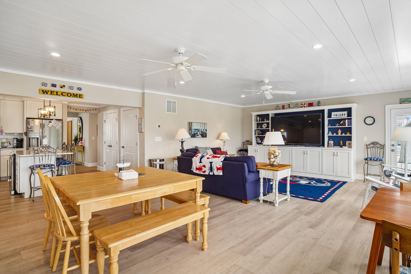 Step inside this welcoming open-concept space where your family can gather around the farmhouse dining table, relax on cozy seating, and enjoy entertainment together—all under bright, airy ceilings that make you feel right at home.