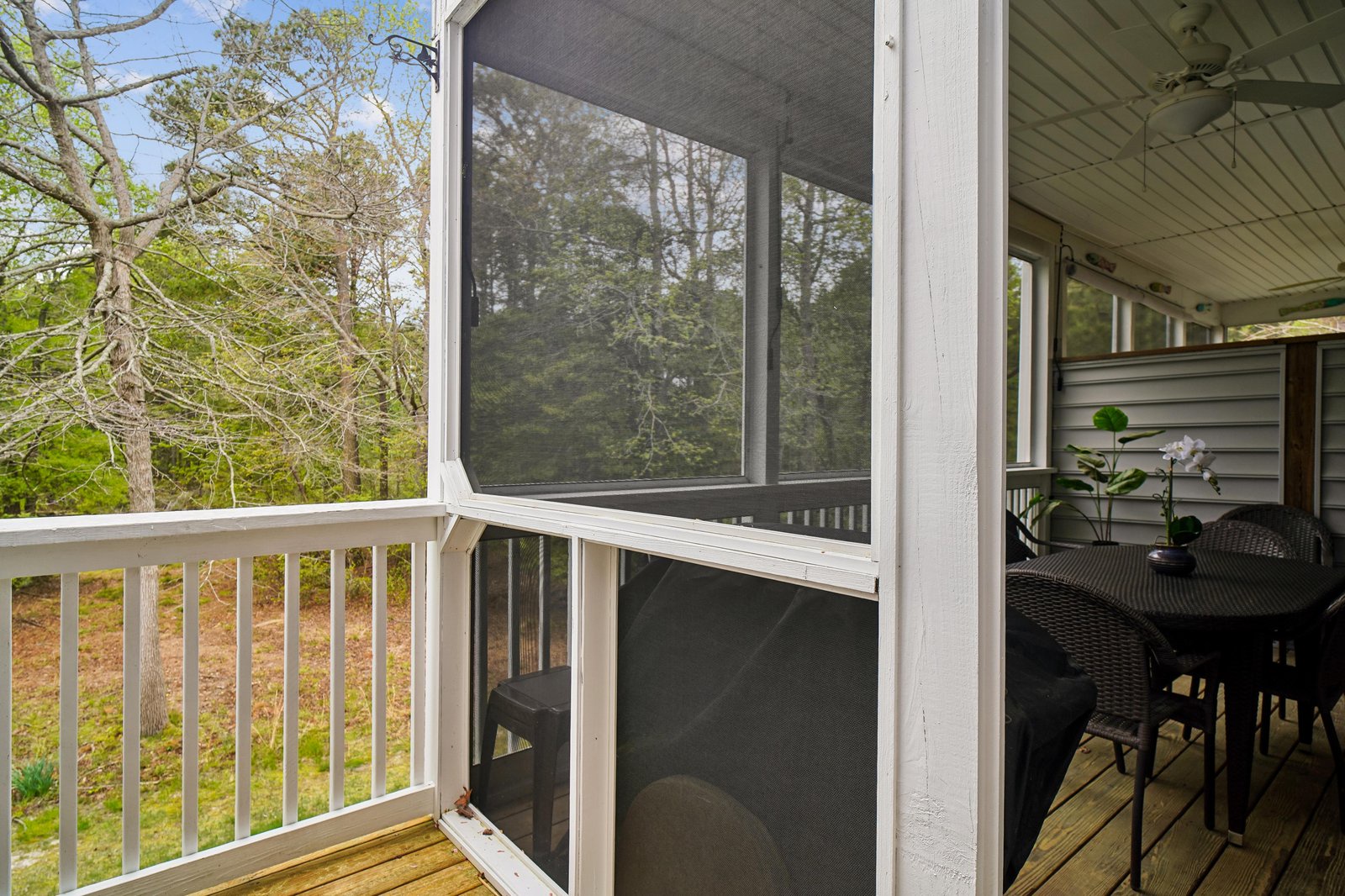 A screened-in porch offers a peaceful spot to enjoy meals or morning coffee surrounded by natural wooded views. The outdoor dining area provides bug-free relaxation in the fresh air.