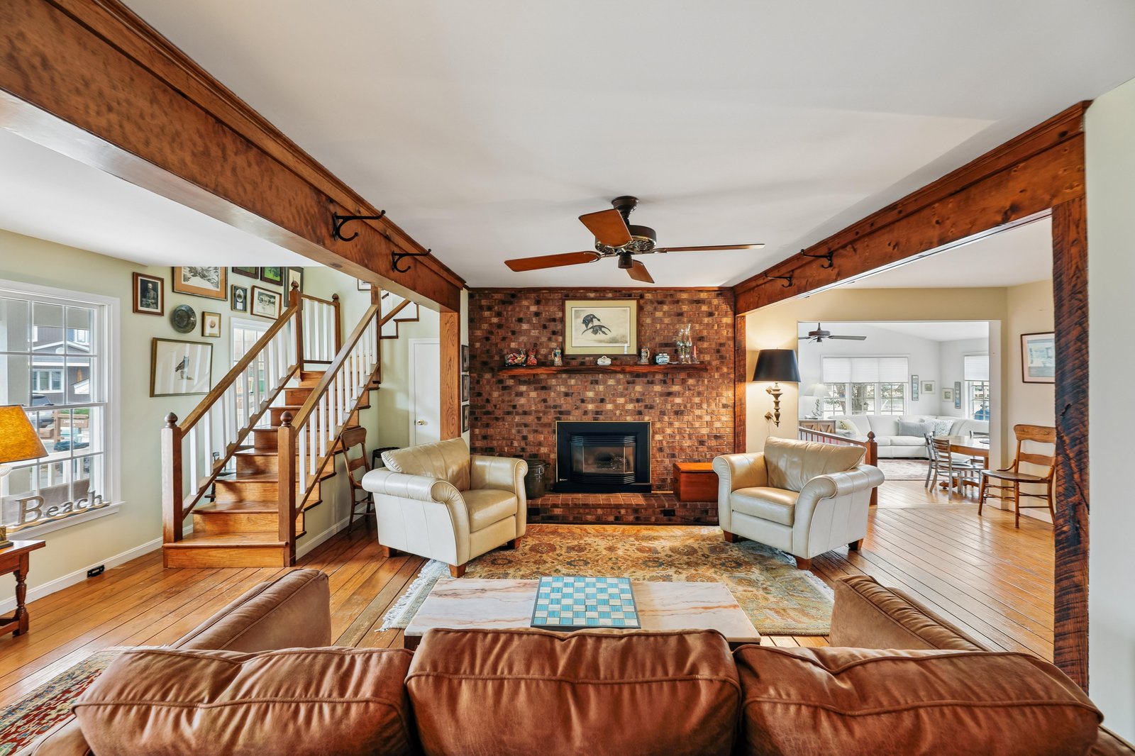 Sink into plush leather seating by your brick fireplace, where rich wood beams and hardwood floors create a warm retreat perfect for gathering with loved ones.