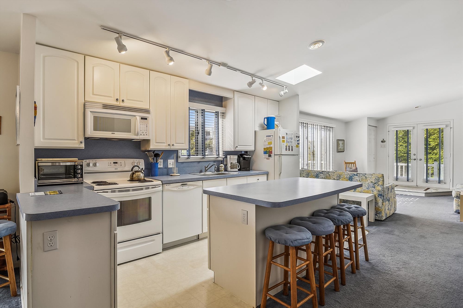 Your spacious kitchen and living area blend comfort and function, with natural light pouring through skylights and doors that open to your private outdoor space.