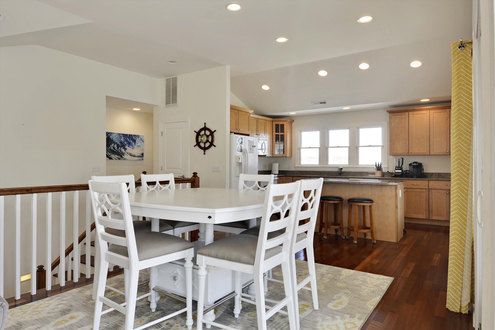 Gather around the table for meals and conversation in this open, light-filled space where the kitchen flows seamlessly into the dining area, creating a warm and inviting atmosphere.