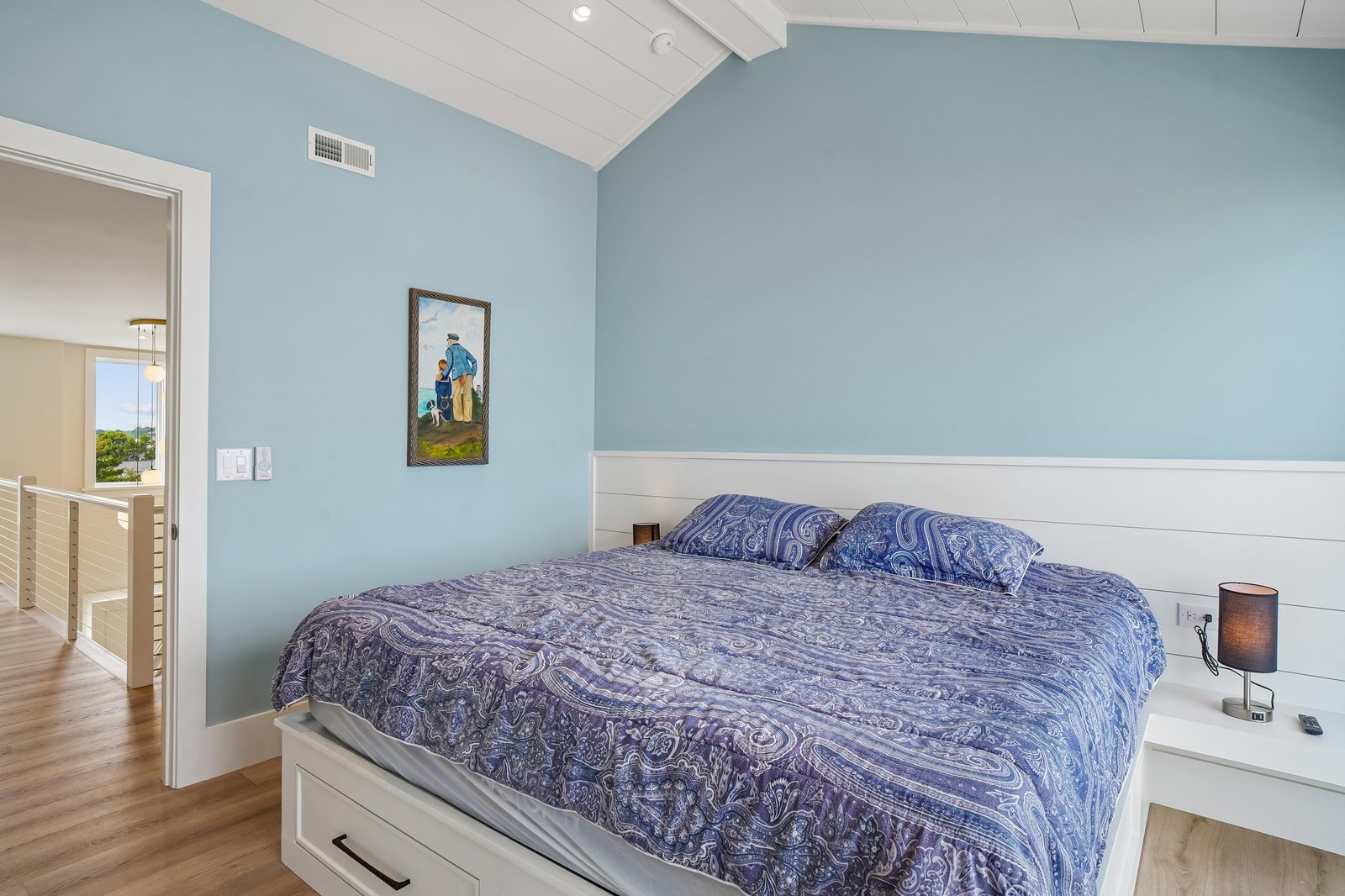 Drift off under vaulted ceilings and coastal blue walls, where bright mornings and soft linens make your island retreat feel like home.