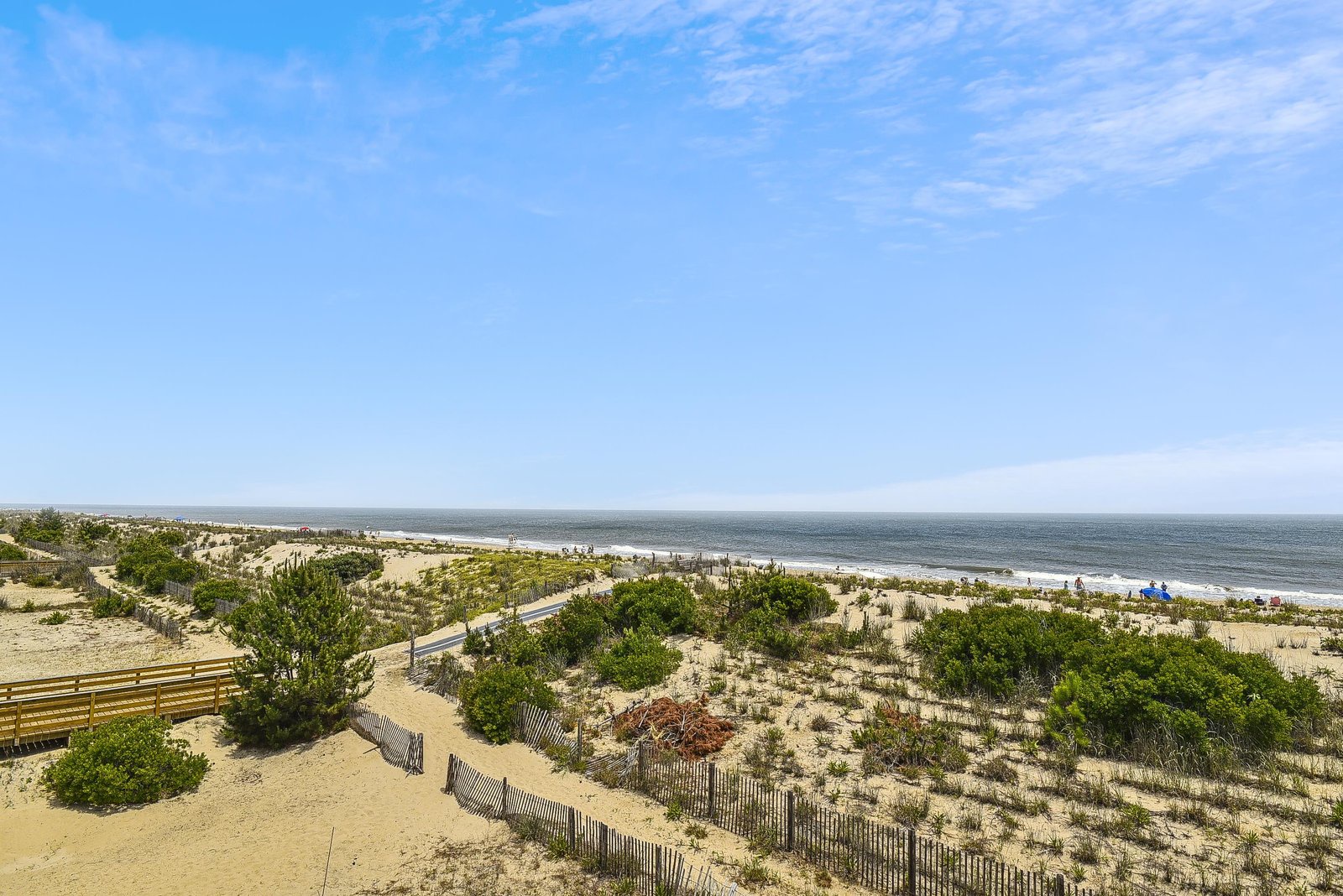 Elevated beachfront perspective showcasing sandy dunes, natural vegetation, and the inviting oceanfront setting.