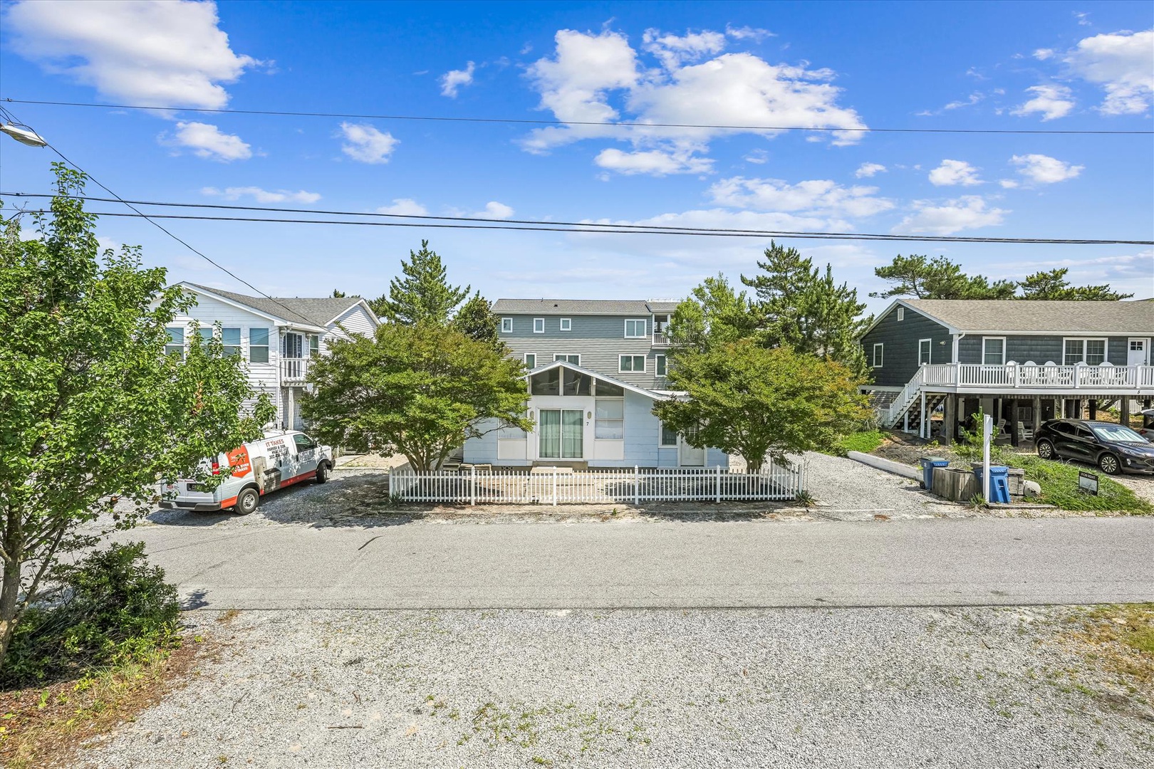 Charming coastal neighborhood with beach houses and tree-lined streets, offering a peaceful residential setting for vacation stays.