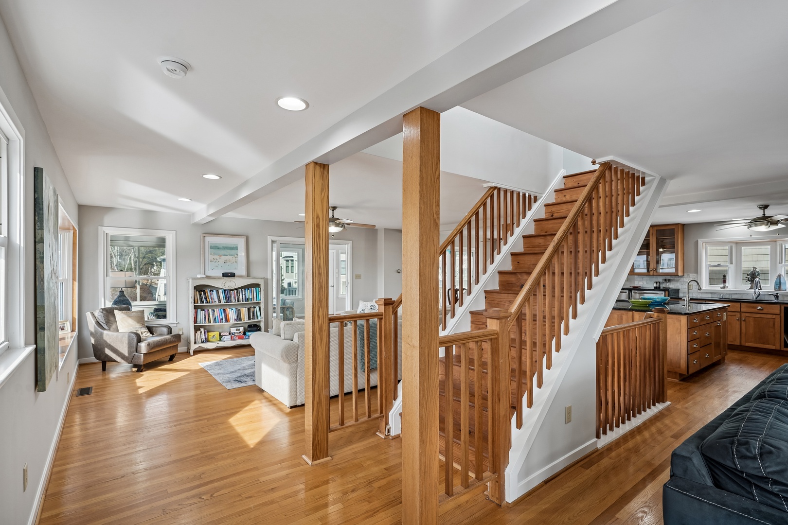 Your spacious open living space features warm hardwood floors, built-in bookshelves, and a beautiful wooden staircase creating the perfect home base.