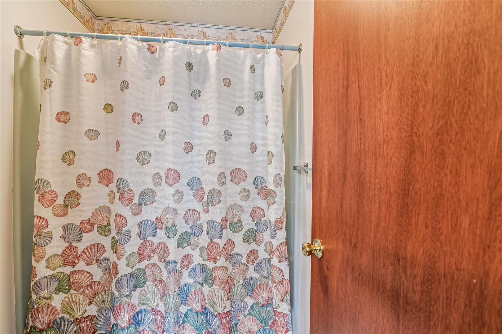 Step into your private bathroom, where a cheerful seashell-patterned curtain adds a playful coastal touch. Bright and welcoming, this space makes freshening up feel easy and carefree.