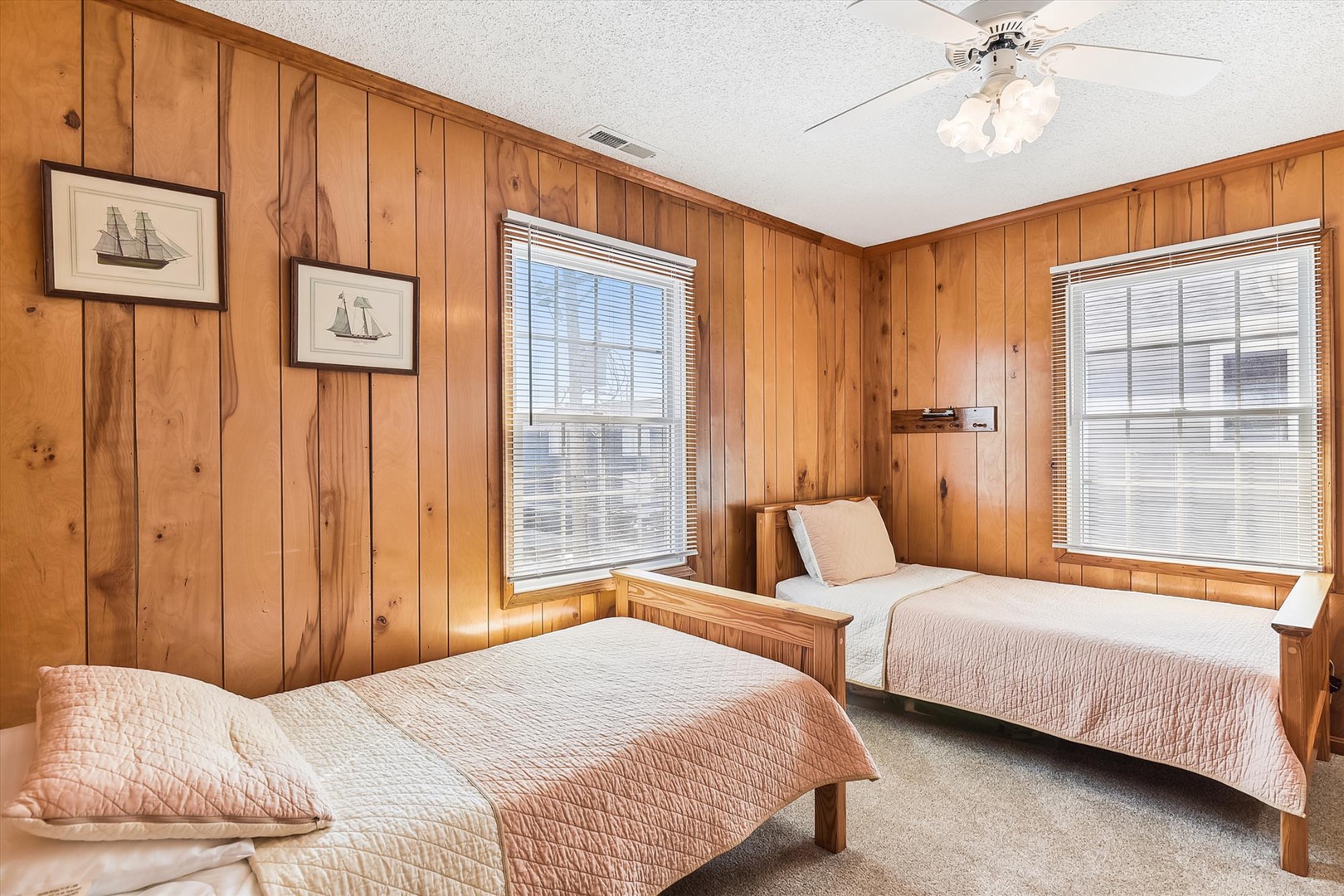 Your cozy twin bedroom with warm wood paneling and nautical touches awaits—perfect for restful nights after a day of adventure.