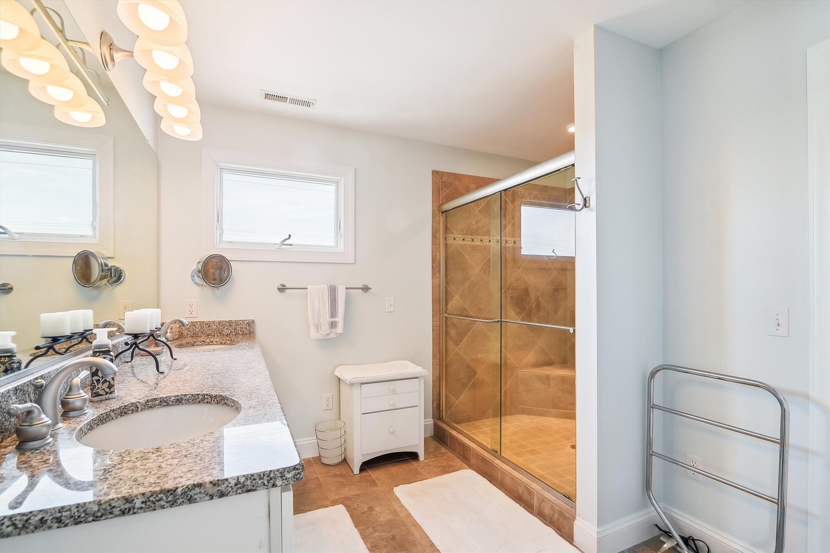 Indulge in your private spa-like bathroom featuring granite countertops, elegant lighting, and a stunning walk-in shower with beautiful tile work.