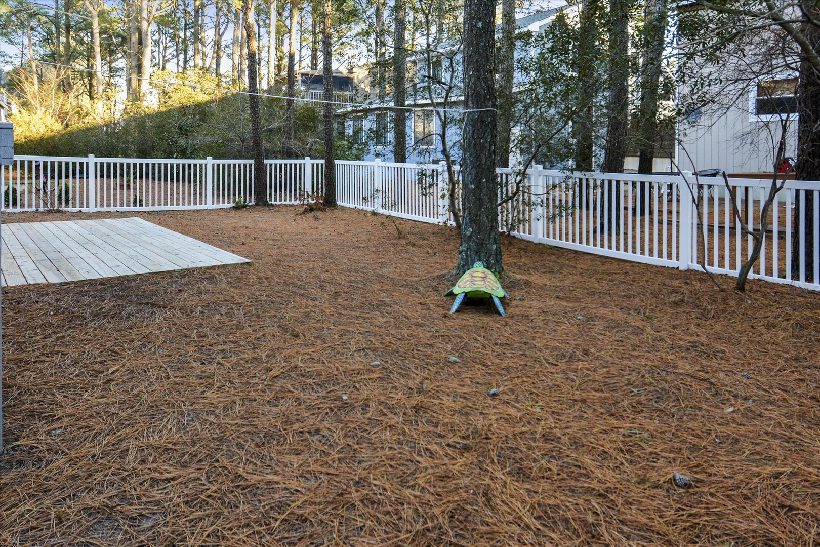 A private fenced backyard provides a secure, peaceful outdoor retreat among tall trees, complete with a deck for relaxing or dining alfresco.