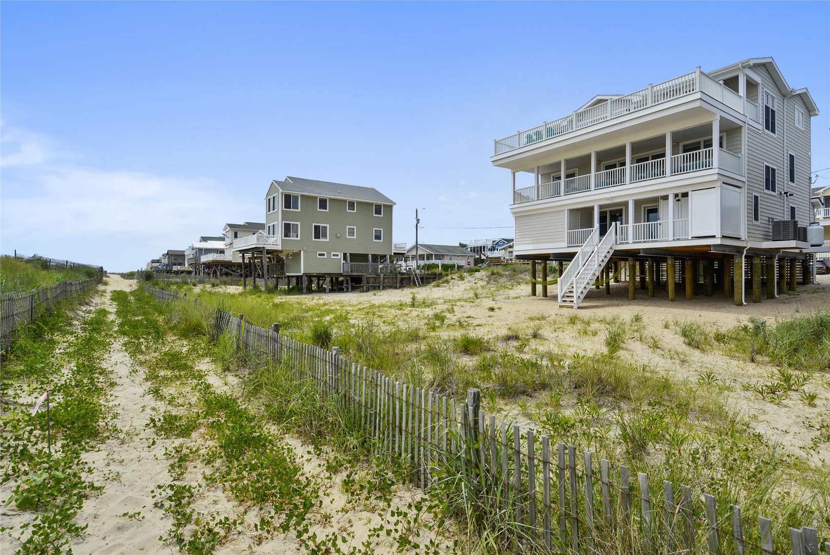 Beachfront property with direct access to sandy shores, offering a coastal getaway surrounded by dunes and sea grasses just steps from the ocean.