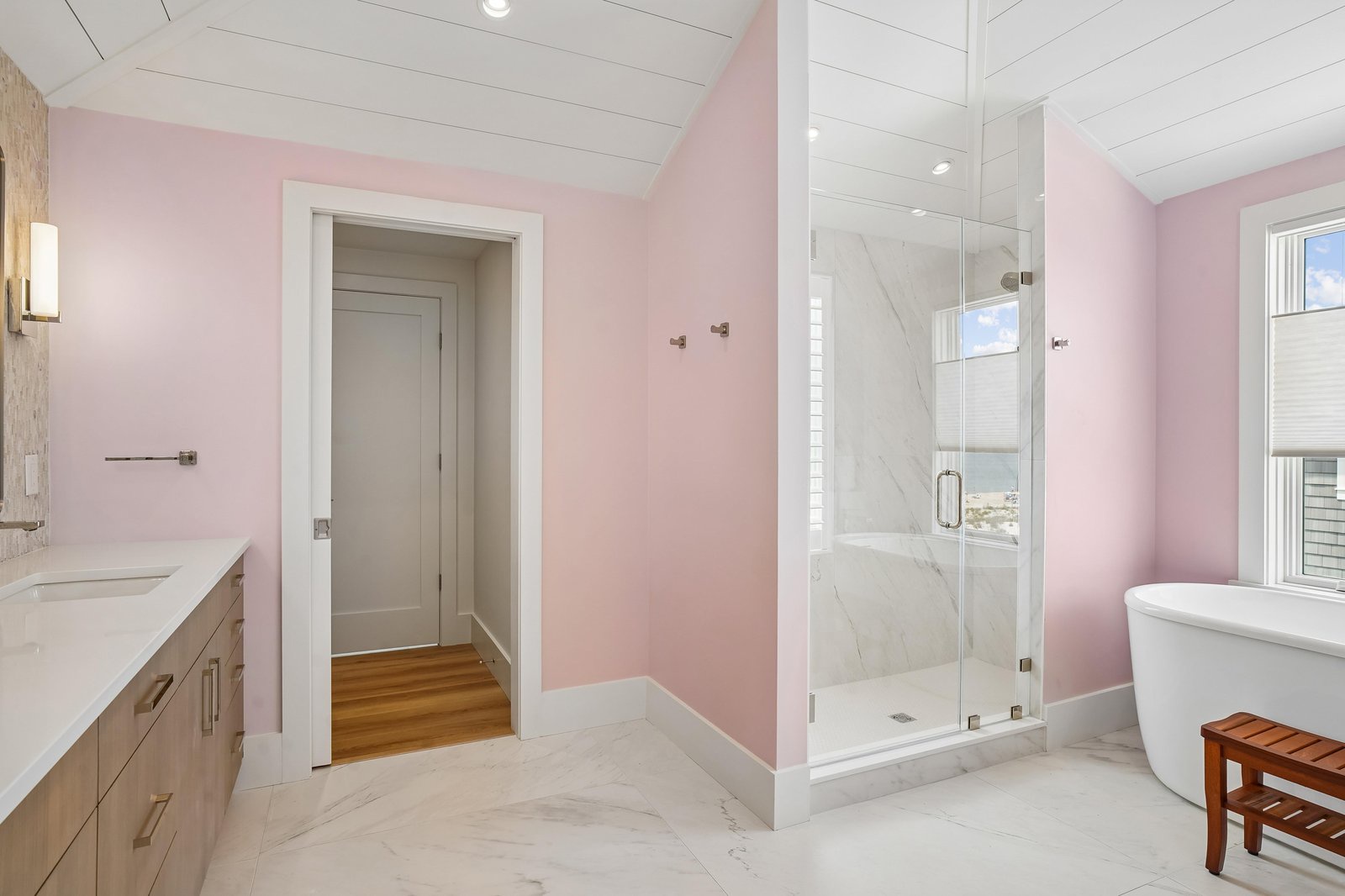 Soak in the elegant freestanding tub or refresh in the walk-in shower surrounded by soft pink tones and bright natural light from your private window.