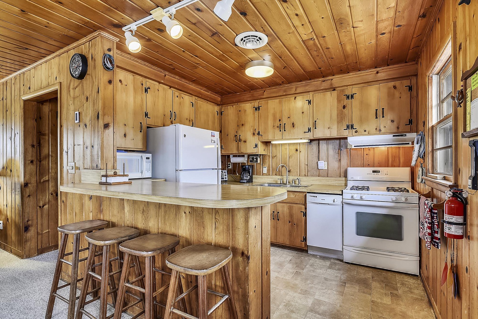 Step into your fully equipped kitchen with warm wood finishes, modern appliances, and a cozy breakfast bar—perfect for preparing meals and gathering with friends.