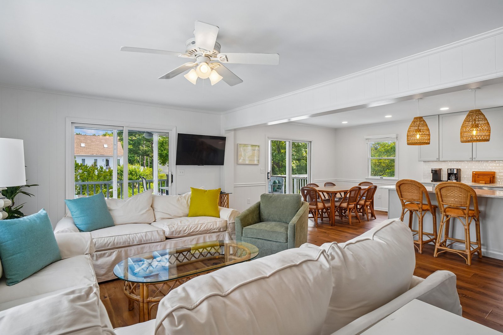 Sink into plush sofas and gather around the stylish glass coffee table in this sun-filled living space, where coastal charm meets comfort. Your vacation home flows seamlessly into a welcoming dining area and fully equipped kitchen.