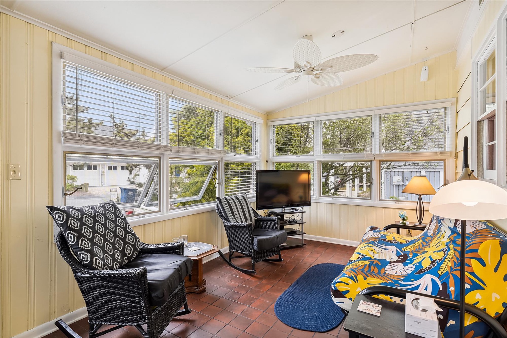 Unwind in your sun-soaked enclosed porch, where comfortable wicker seating and abundant windows invite you to relax with your favorite show or simply soak in the peaceful neighborhood views.