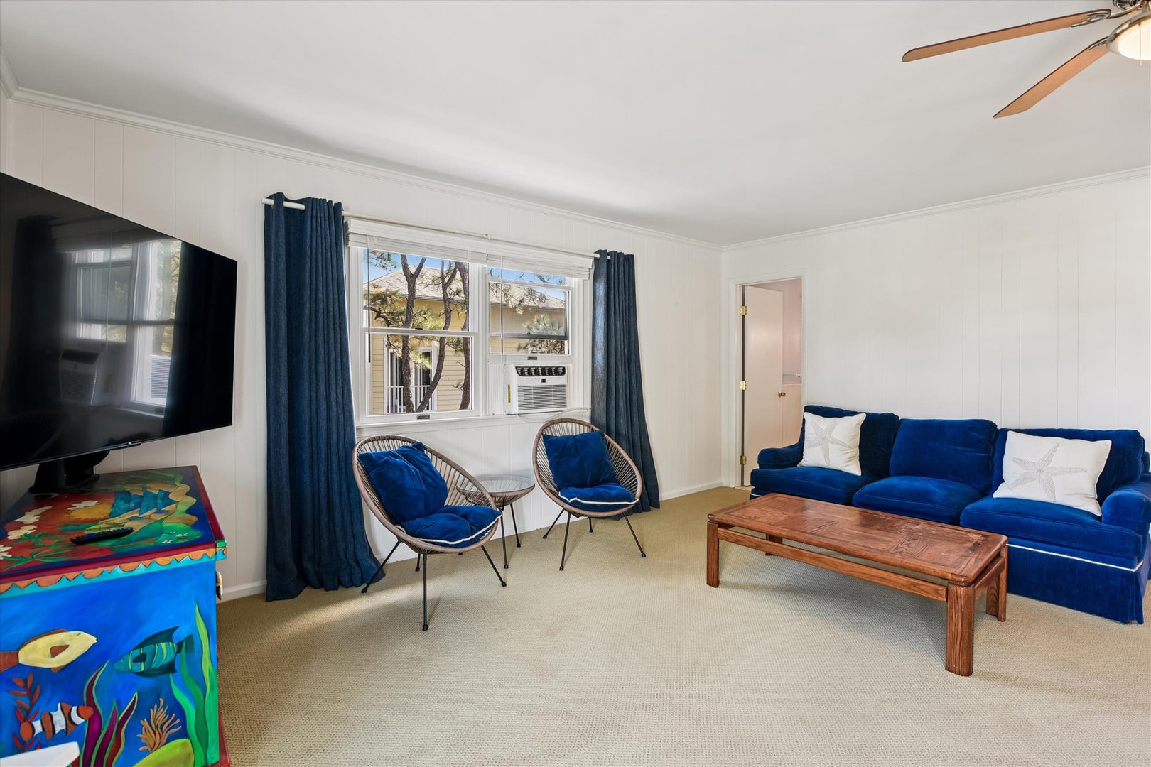 Unwind in your bright living space with plush blue seating and modern touches, where comfort meets style.