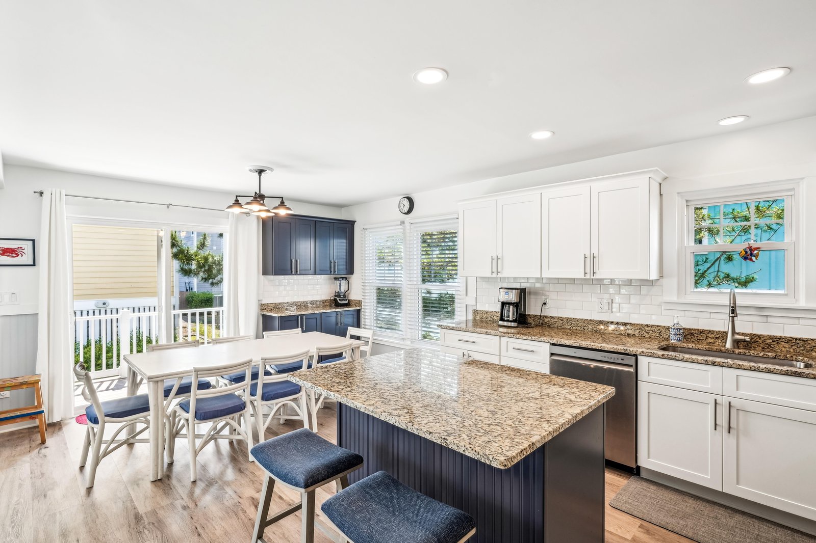 Prepare meals together in this bright, open kitchen featuring granite countertops, modern appliances, and a spacious island with seating for casual dining.