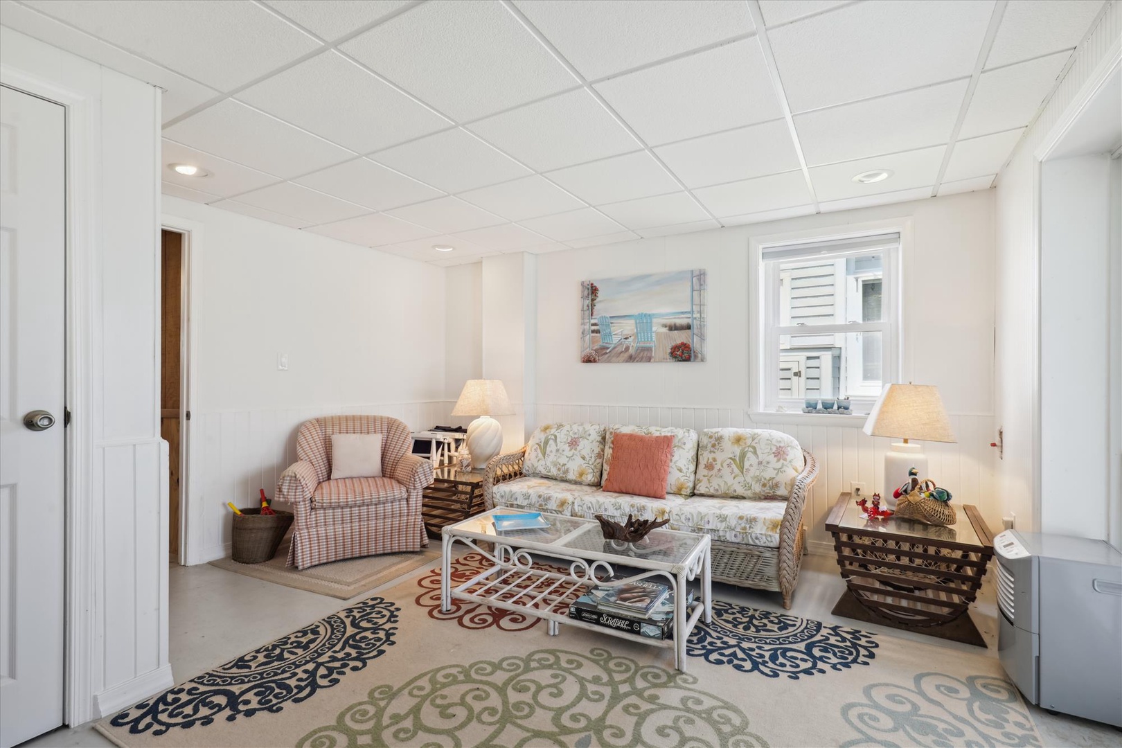 A bright, coastal-themed living area invites you to relax in comfort. Soft lighting and charming decor create a cozy retreat for unwinding after beach adventures.