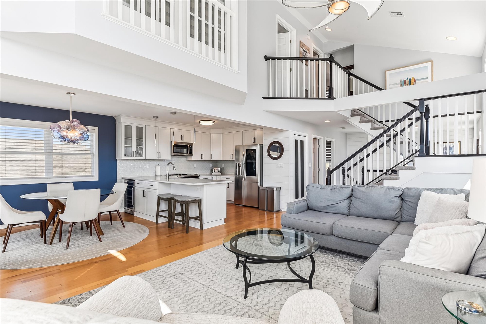 Relax in your spacious two-story retreat featuring an open layout with modern kitchen, dining nook, and plush living area—plus high ceilings and warm hardwood floors throughout.