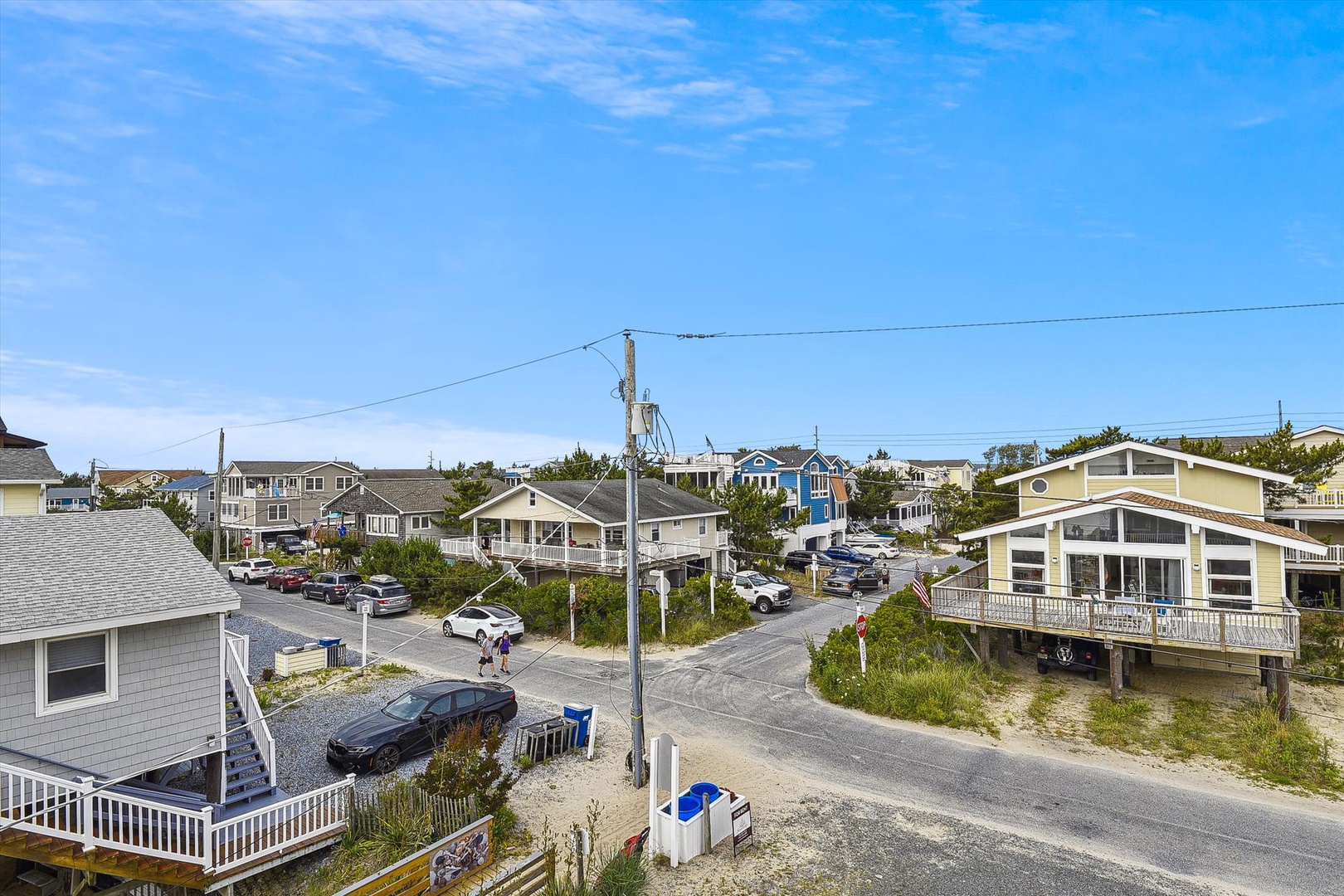 Coastal beach community with mix of traditional and modern homes along sandy streets near the shore.