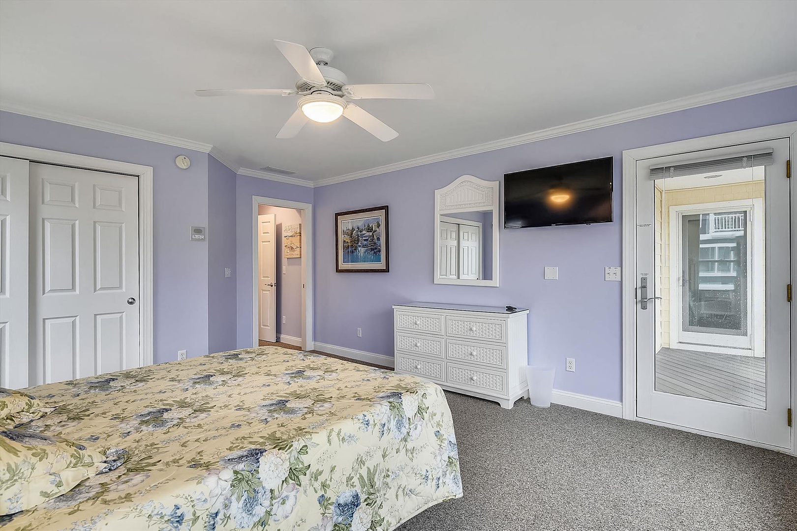 Unwind in your serene bedroom with soft lavender walls, a ceiling fan to keep you cool, and your private balcony entrance just steps away.