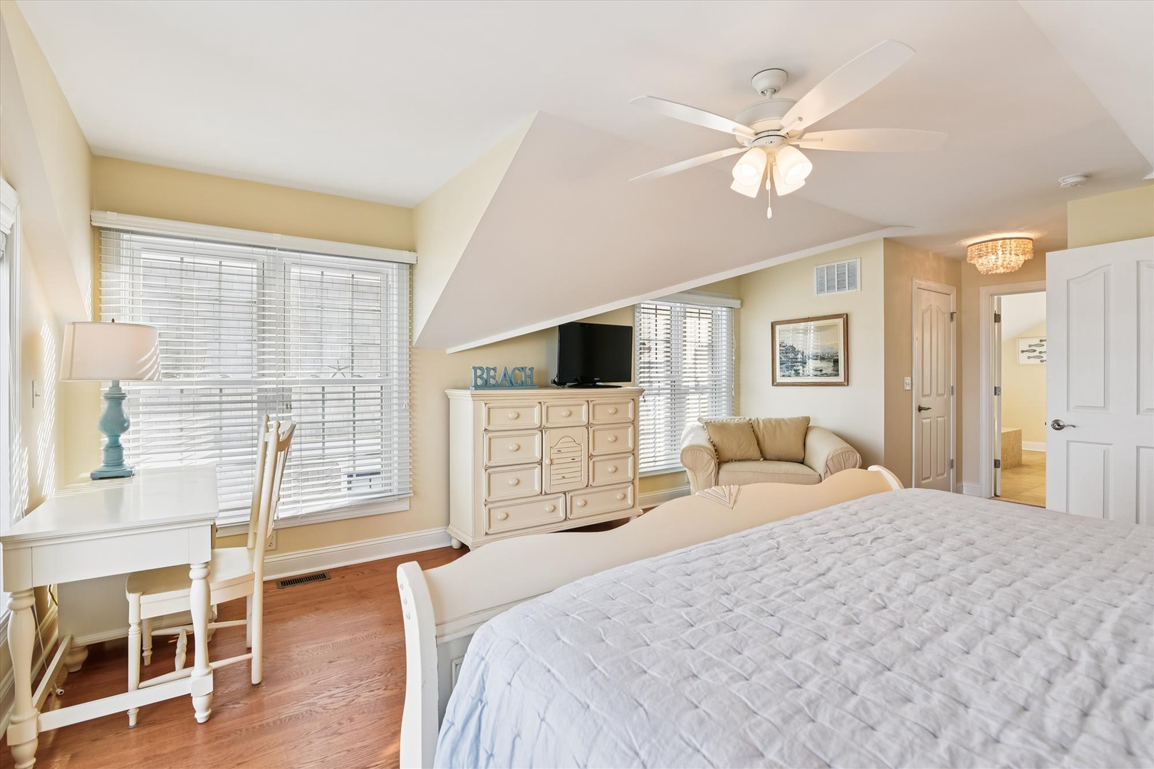 Your peaceful bedroom retreat features soft coastal decor, a cozy reading nook by the window, and plenty of space to unwind after beach days.