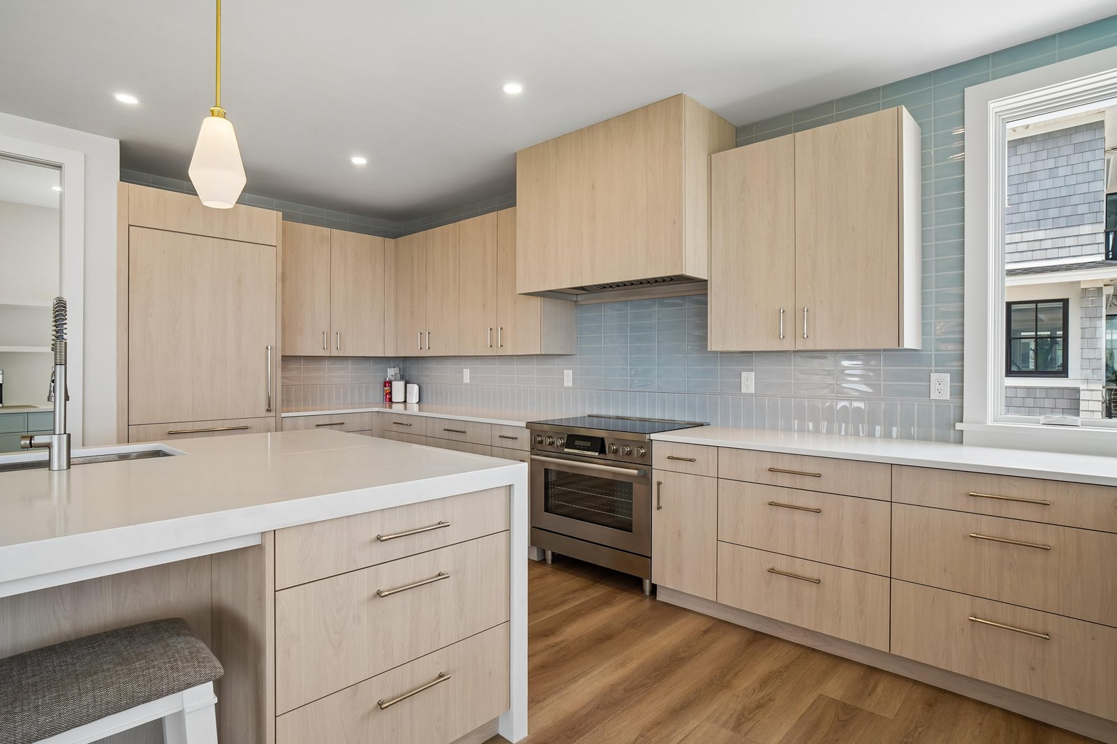 Your fully equipped kitchen makes meal prep a breeze, with sleek countertops, modern appliances, and plenty of cabinet space to spread out. Light wood tones and cool blue tile give it a fresh, coastal-inspired feel.