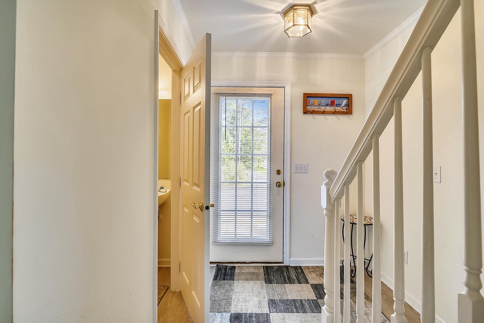 The welcoming entryway leads into your retreat, where natural light streams through the glass door and charming details set a warm, inviting tone for your stay.