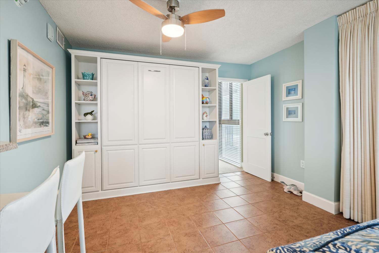 Settle into your peaceful coastal retreat with soothing blue walls, built-in storage, and coastal decor that invites relaxation after a day of seaside adventures.