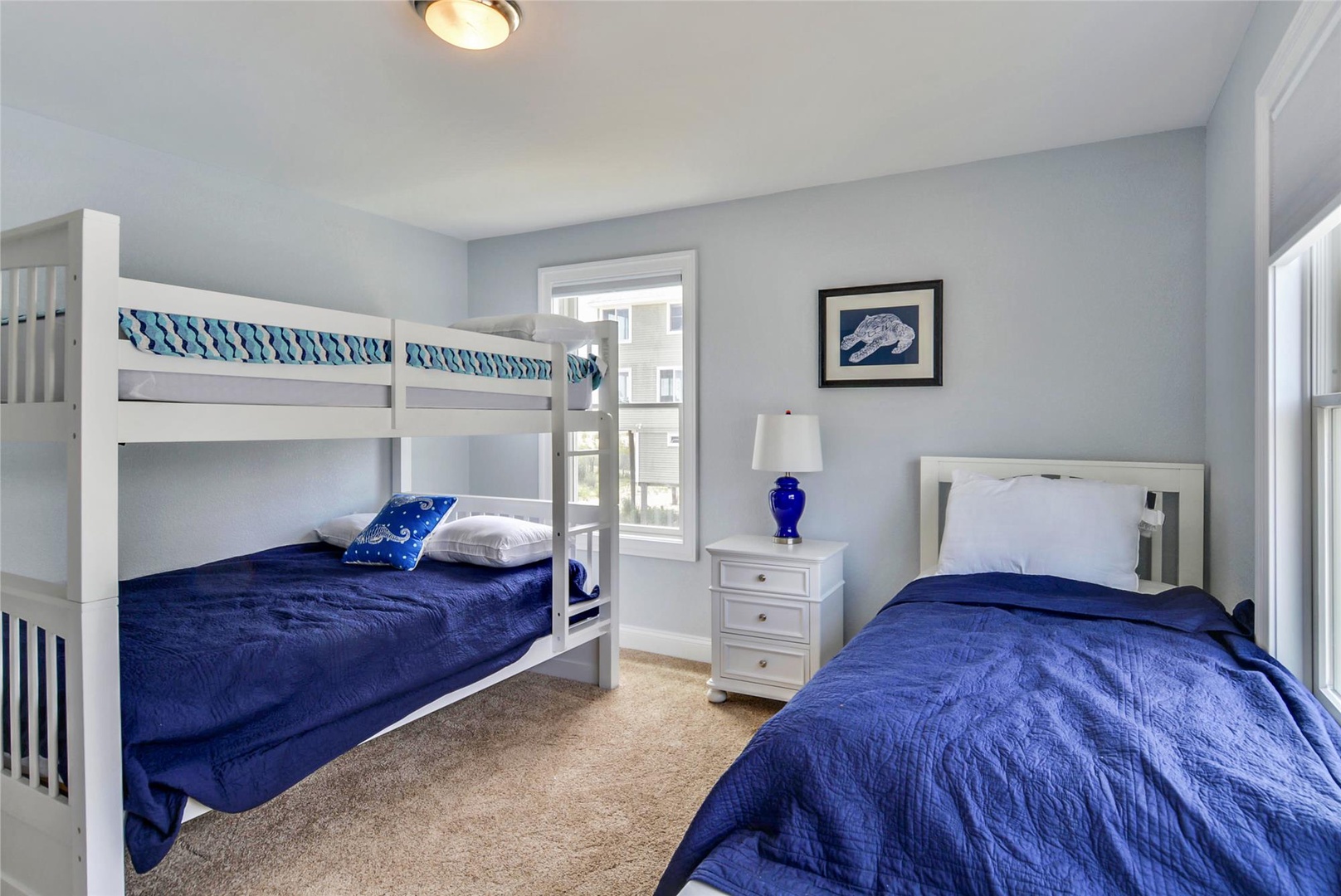 Settle in for a peaceful night's sleep in this coastal-themed bedroom with comfy beds for the whole family and calming blue tones throughout.