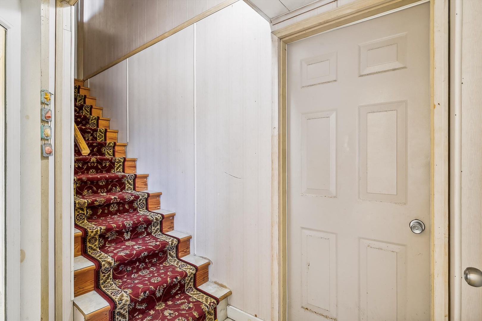 An inviting staircase leads you upstairs, featuring warm wood steps and elegant patterned carpet that adds character and comfort to your private retreat.