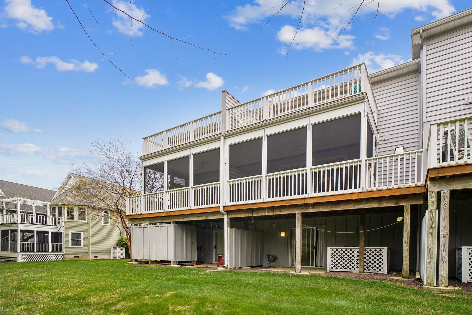 Spacious vacation home with expansive screened porch and large backyard perfect for outdoor gatherings and relaxation in a peaceful neighborhood setting.