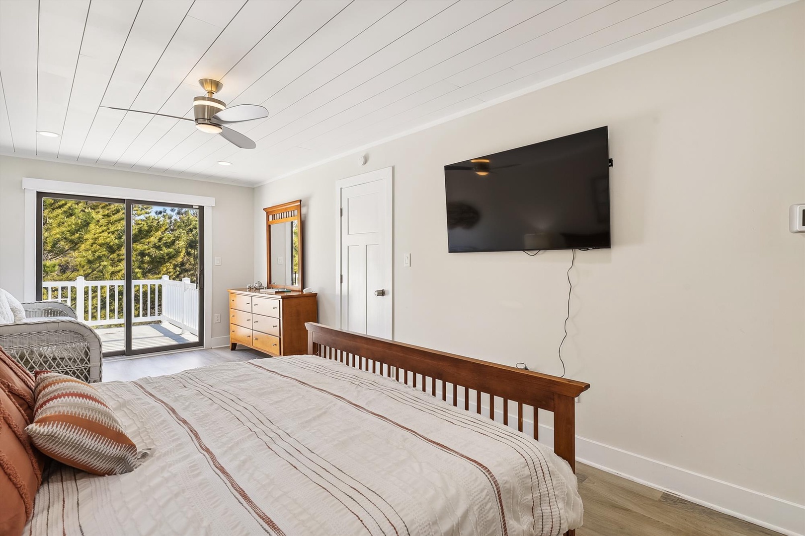 Wake up in your bright, peaceful bedroom with leafy treetop views and a private balcony where morning coffee feels like a mini-escape, complete with modern comforts and charming wood details.