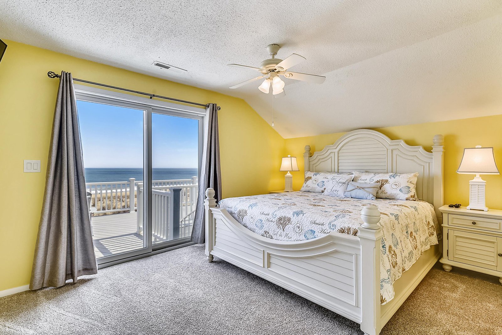 Wake up to the gentle sound of waves and sunlight streaming through your balcony doors. This cheerful bedroom invites you to unwind in coastal comfort, with ocean breezes just steps away.