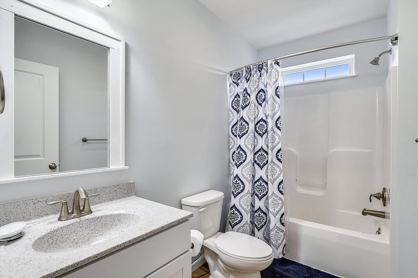 Refresh in your spotless private bathroom with a full tub-shower combo, stylish vanity, and serene blue-and-white décor to start your day feeling revitalized.