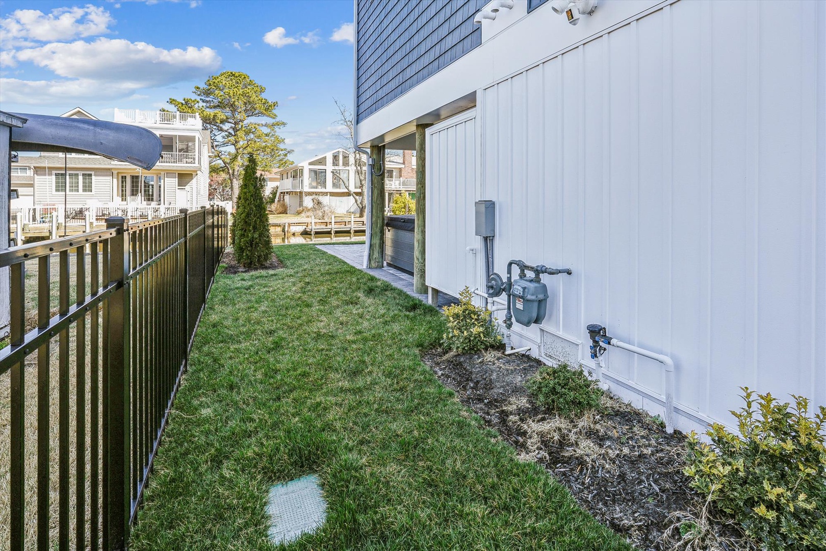 A private side yard with fresh lawn provides a peaceful outdoor space for morning coffee or relaxing between beach outings.