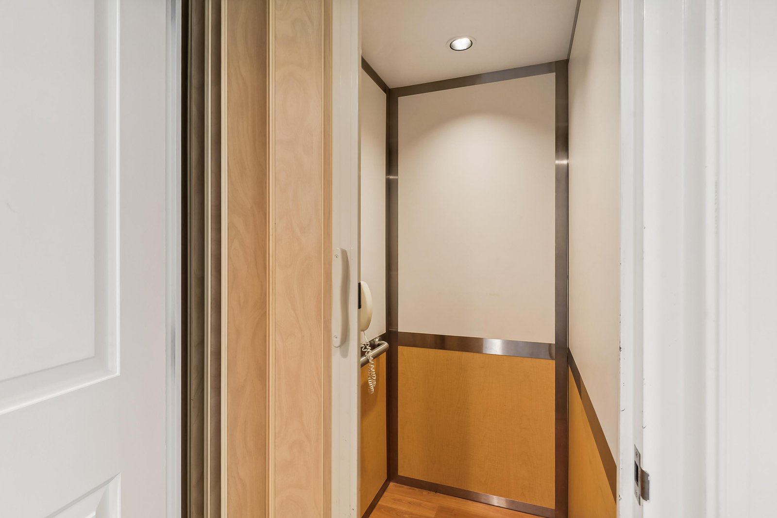 Modern elevator with warm wood accents and thoughtful lighting, making it easy for you to move between floors during your stay.