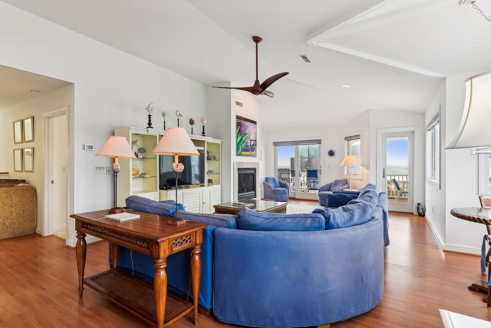Settle into plush blue seating with ocean breezes flowing through your bright, open living space—your coastal retreat awaits.