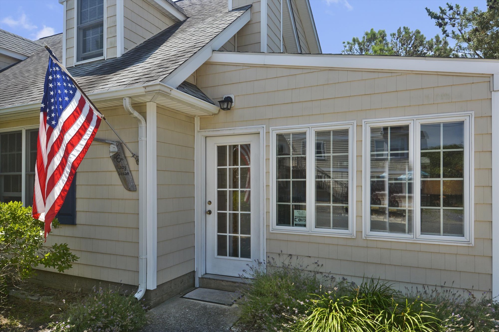 A charming coastal-style entrance with classic beige siding and bright white trim welcomes arrivals to this comfortable vacation retreat.