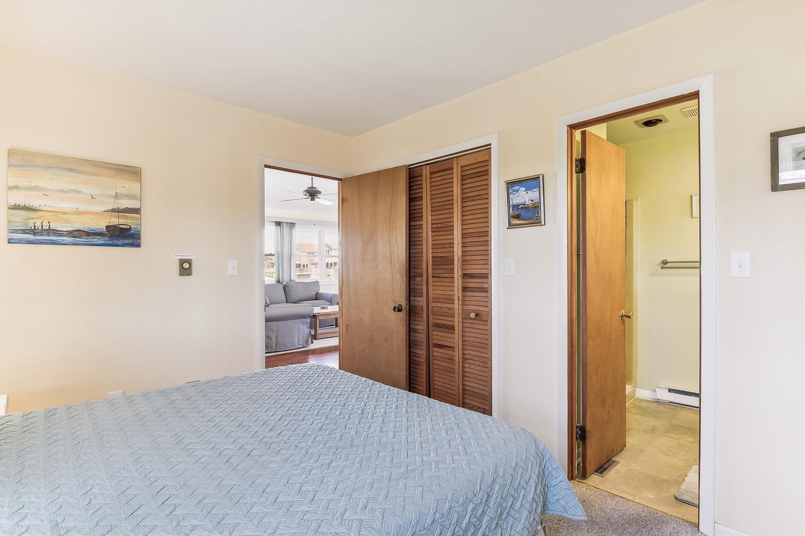 Your restful bedroom opens to a cozy living area and private bathroom, with coastal artwork adding a beachy touch. Enjoy a peaceful retreat designed for your comfort.