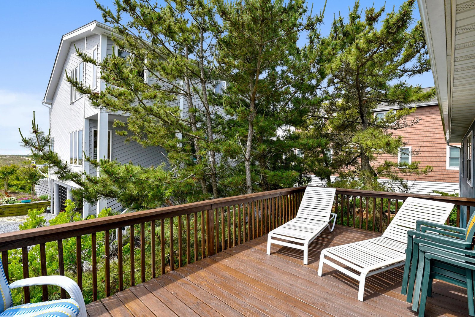 Your private deck overlooks coastal greenery and neighboring homes, offering a peaceful spot to relax outdoors. Stretch out on the lounge chairs and soak up the sunshine.