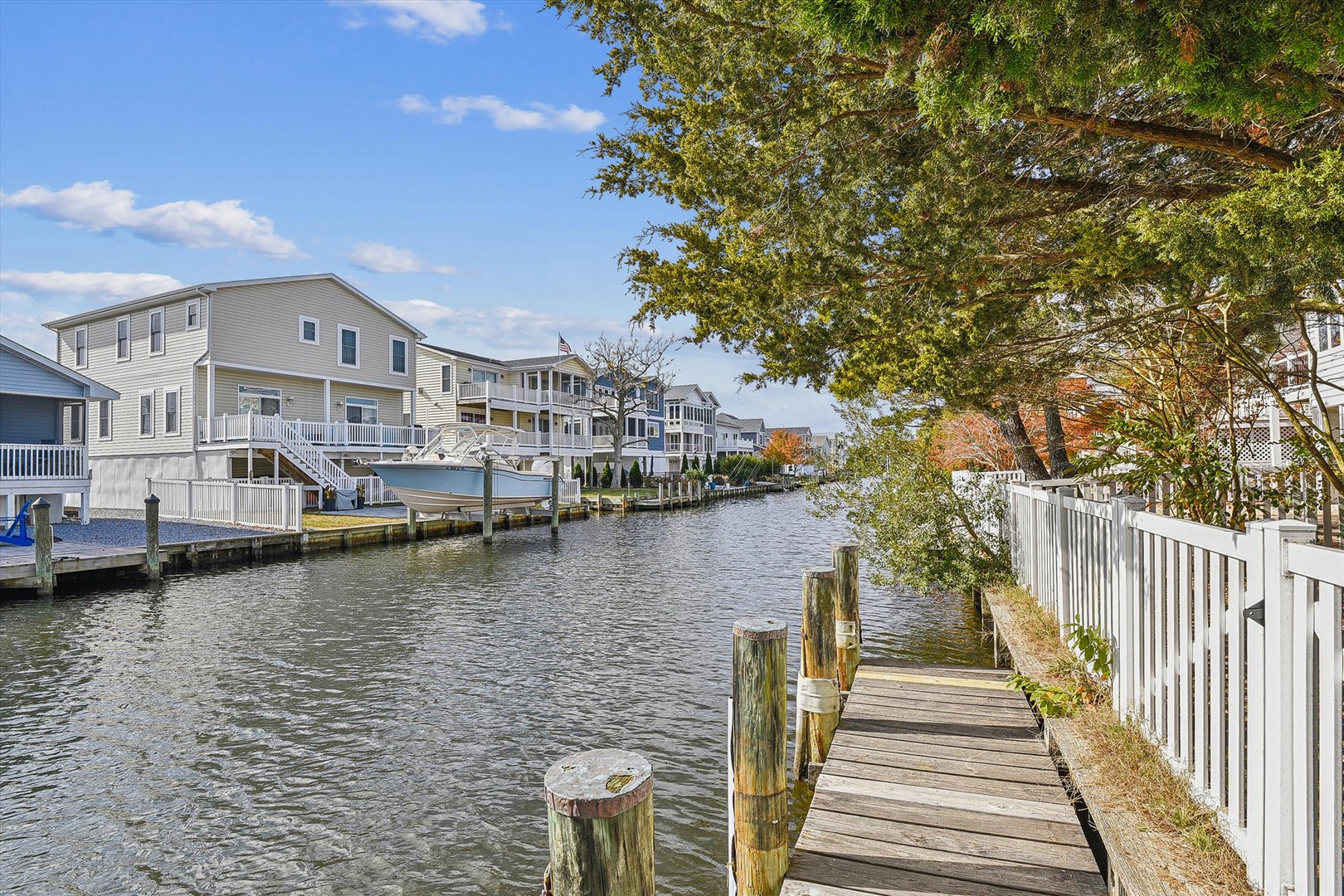 A serene waterfront community featuring canal-style living with private boat docks and charming homes nestled along the peaceful waterway, perfect for water enthusiasts.