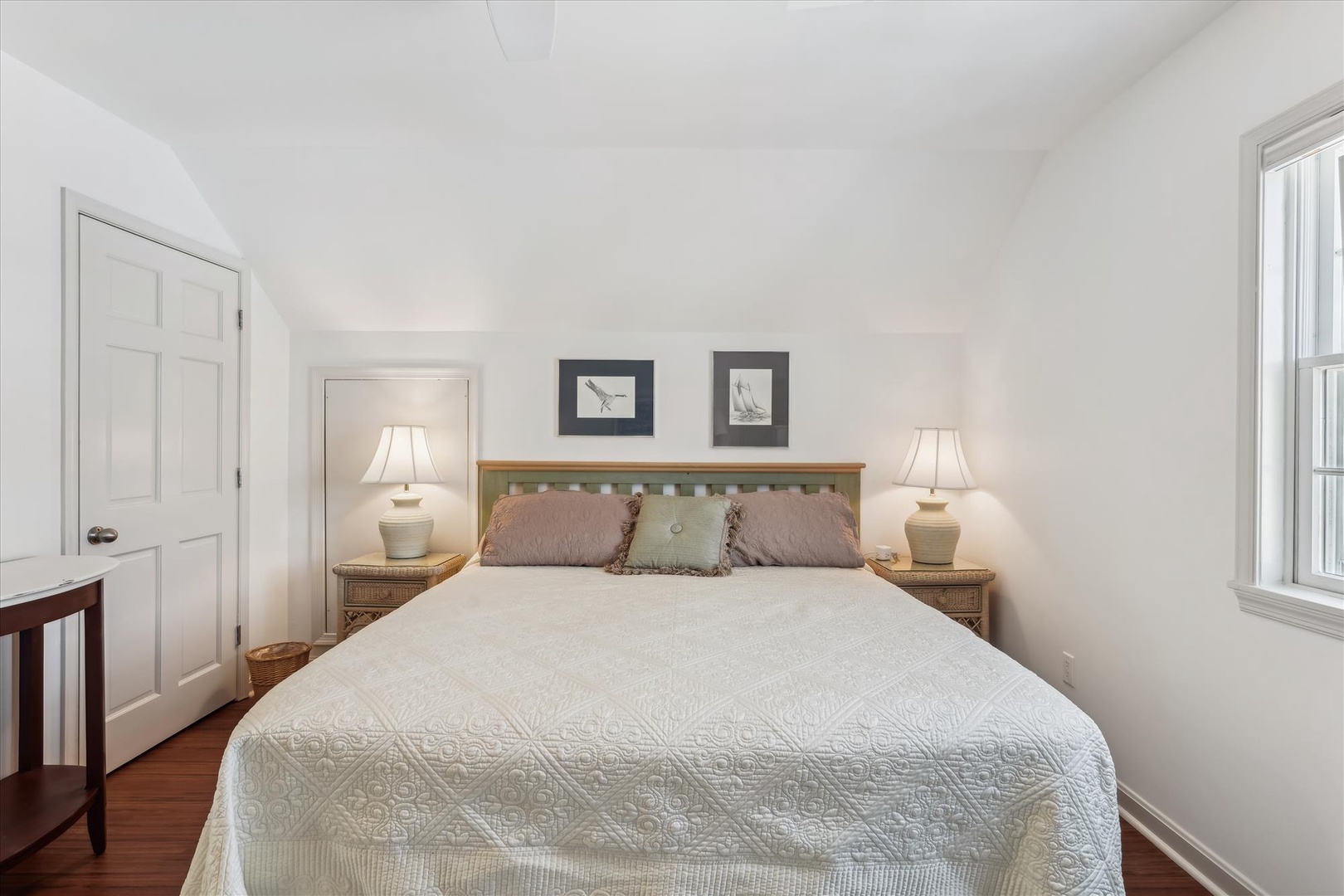 Wake refreshed in this serene, light-filled bedroom, where crisp linens, soft lighting, and coastal accents create your perfect retreat after a day exploring the area.
