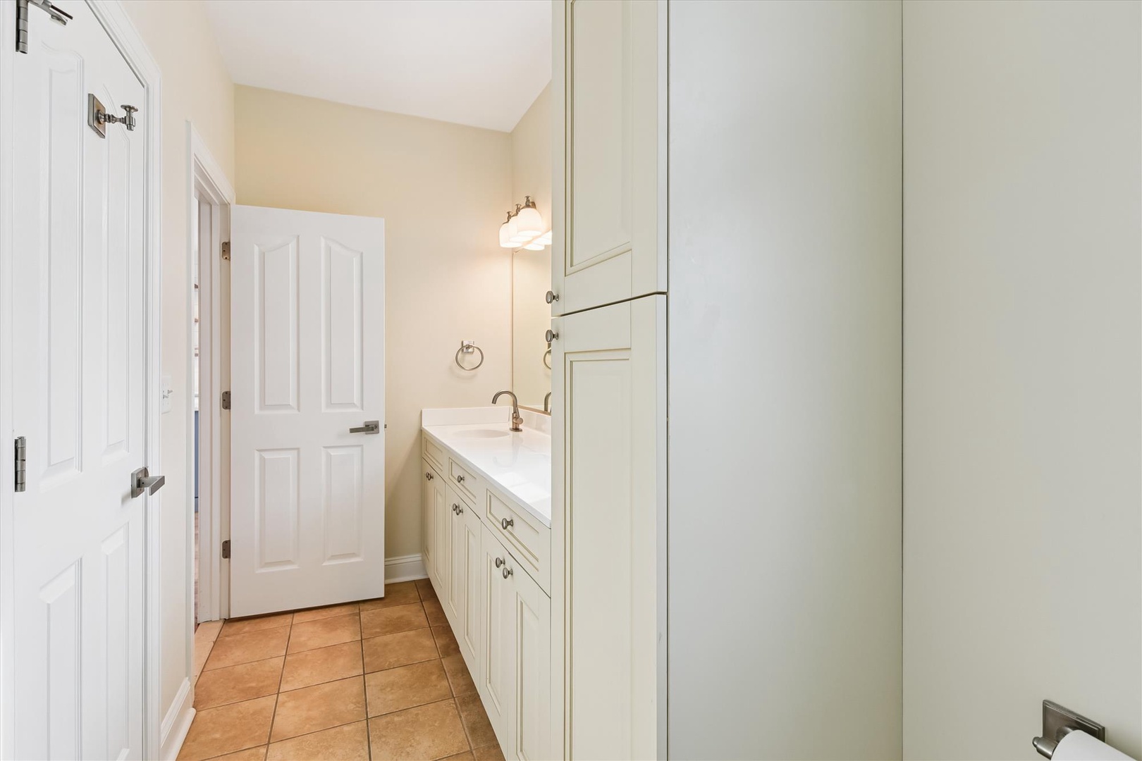 Step into your bright, spotless bathroom with a spacious vanity, large mirror, and warm tile floors—everything you need to feel refreshed and right at home.